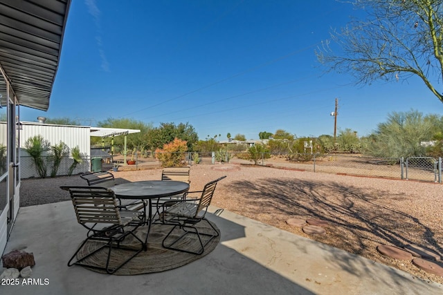 view of patio with outdoor dining area, fence, and a gate