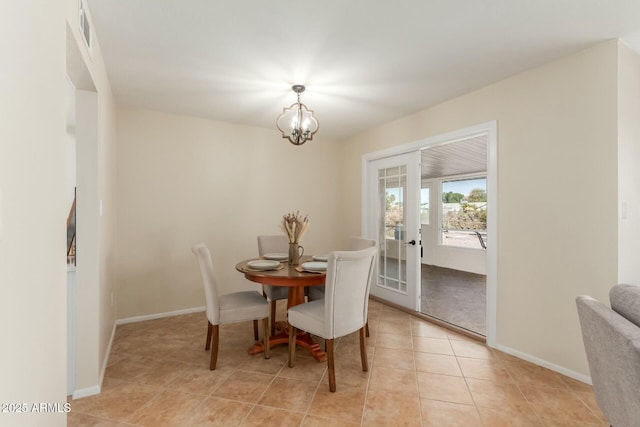 dining area featuring french doors, light tile patterned flooring, a notable chandelier, and baseboards