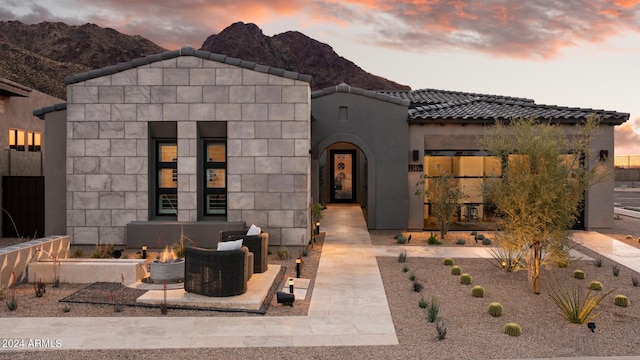 view of front of house with a tiled roof, stucco siding, and a mountain view