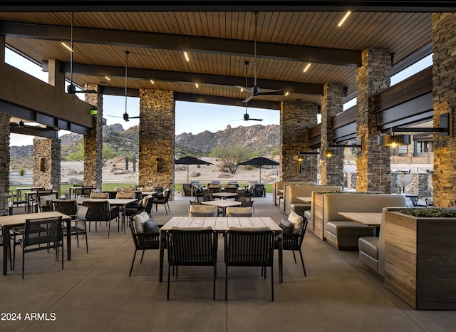 view of patio / terrace with an outdoor living space, a mountain view, outdoor dining area, and ceiling fan