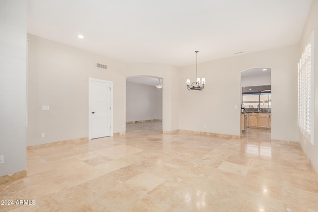 empty room featuring ceiling fan with notable chandelier