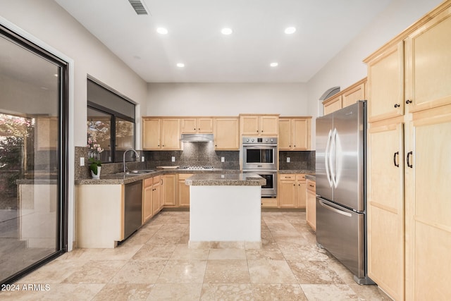 kitchen featuring a center island, light brown cabinets, sink, and stainless steel appliances