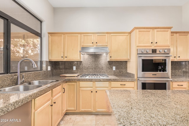 kitchen featuring stainless steel appliances, light tile patterned floors, sink, and tasteful backsplash