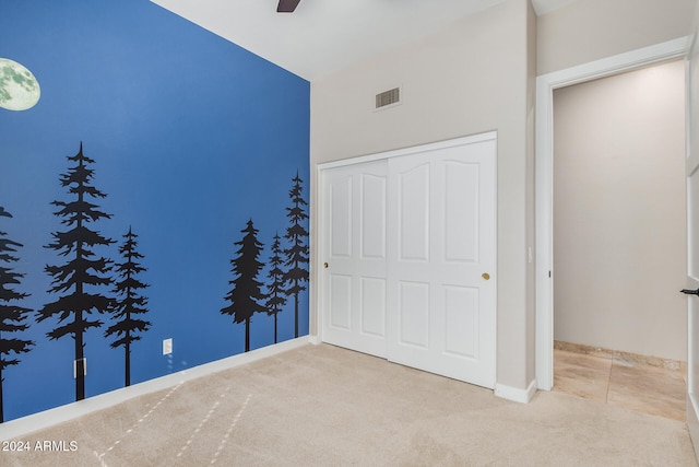 unfurnished bedroom with ceiling fan, a closet, and carpet