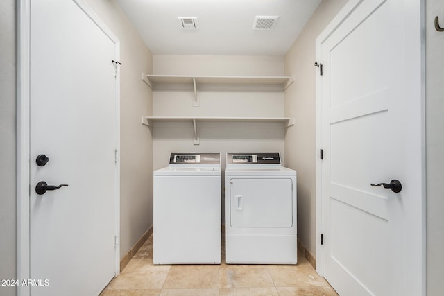 laundry area with independent washer and dryer and light tile patterned flooring