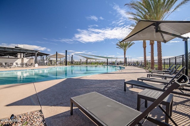 community pool with a patio and fence