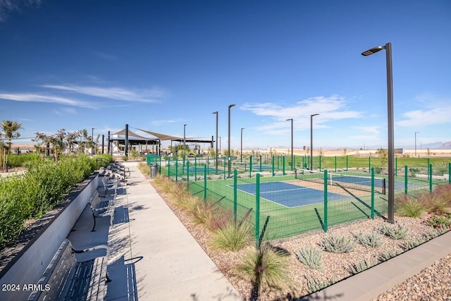 view of tennis court featuring fence and a gazebo