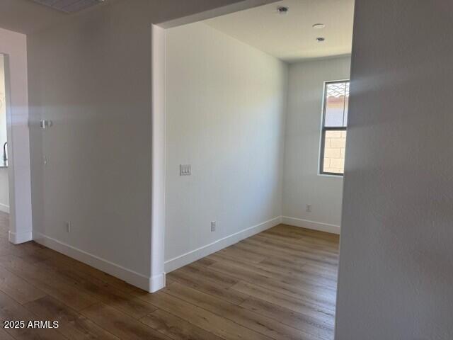 spare room featuring visible vents, wood finished floors, and baseboards