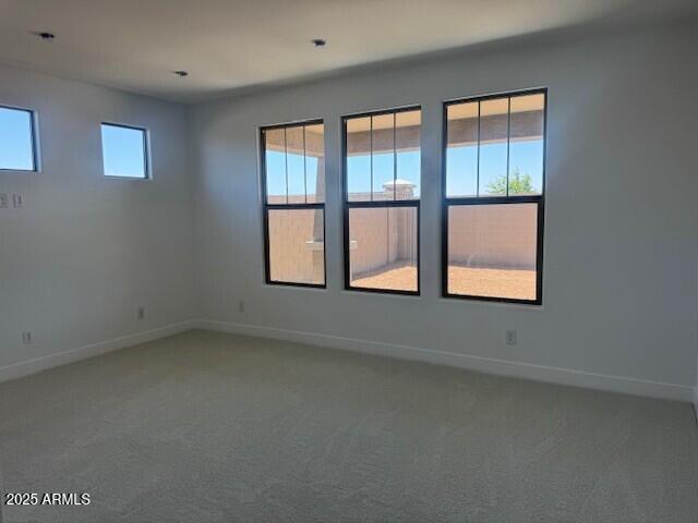 empty room with baseboards and carpet
