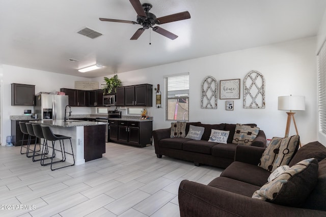 living room featuring sink and ceiling fan