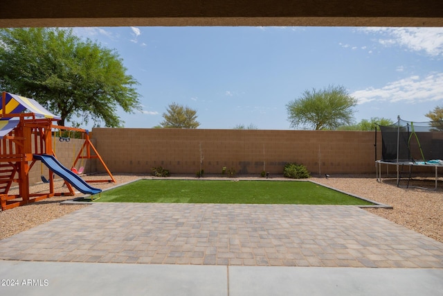 view of yard with a trampoline, a patio area, and a playground