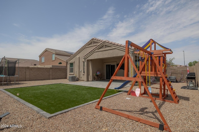 view of playground with central AC unit, a lawn, a trampoline, and a patio area