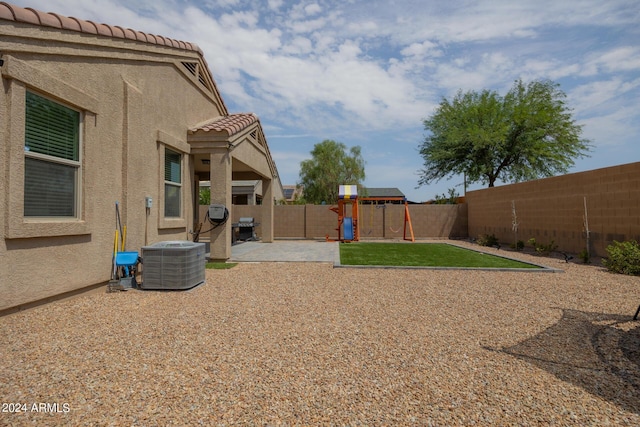 view of yard featuring a patio area, a playground, and central air condition unit