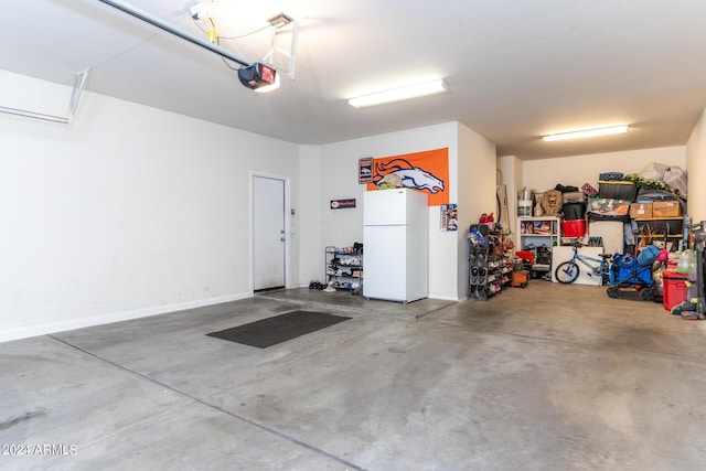 garage with white refrigerator and a garage door opener