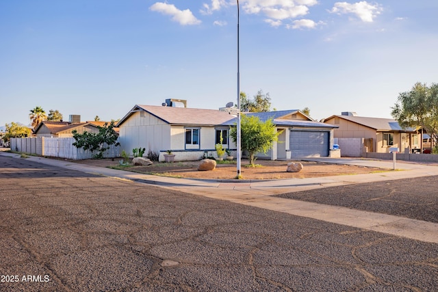 8021 W Hazelwood St, Phoenix, AZ 85033 - view of front of home with fence, concrete driveway, a garage, a residential view, and board and batten siding