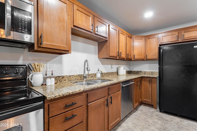 8021 W Hazelwood St, Phoenix, AZ 85033 - kitchen featuring stainless steel appliances, a sink, light stone counters, and brown cabinets
