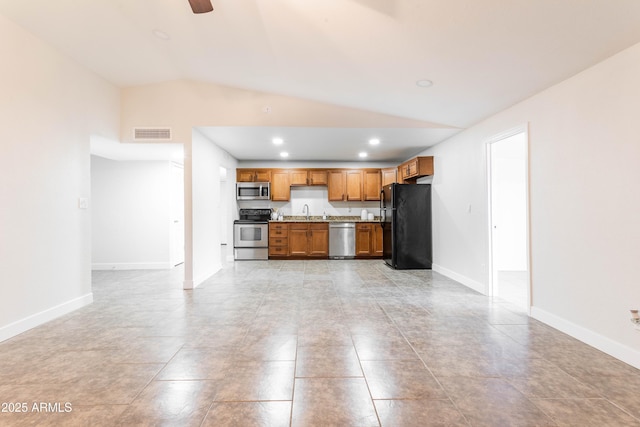8021 W Hazelwood St, Phoenix, AZ 85033 - kitchen with appliances with stainless steel finishes, vaulted ceiling, light countertops, recessed lighting, and brown cabinets