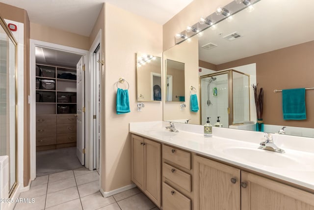 bathroom with walk in shower, vanity, and tile patterned flooring