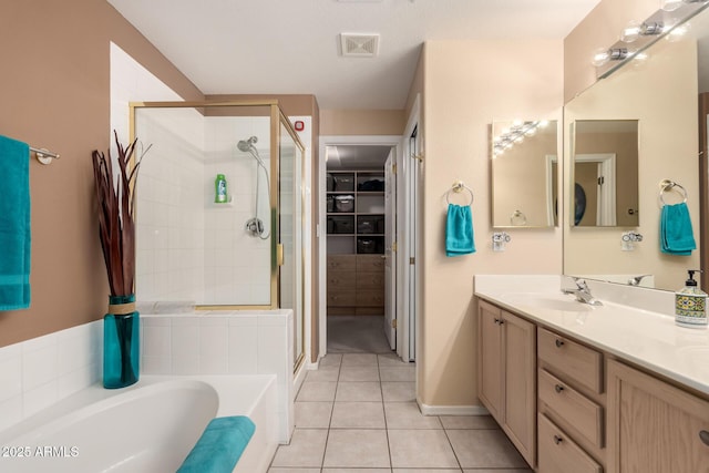 bathroom featuring tile patterned flooring, vanity, and separate shower and tub