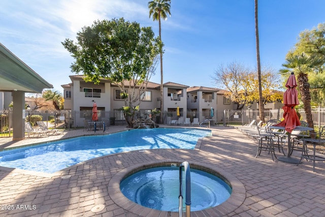 view of swimming pool featuring a hot tub and a patio