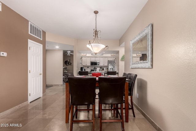 tiled dining room featuring ceiling fan