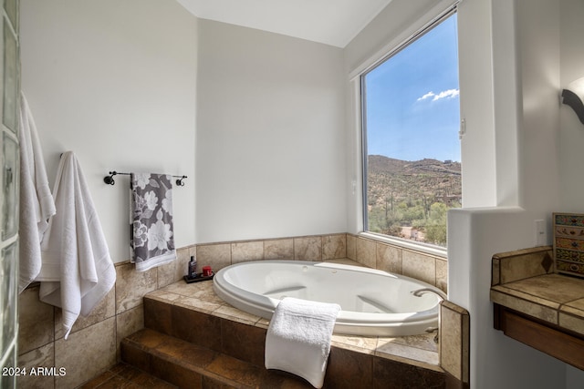 bathroom featuring a mountain view and tiled bath