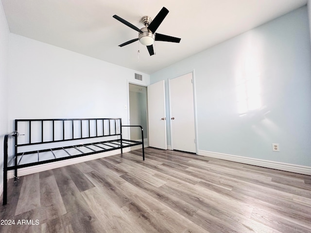 unfurnished bedroom with ceiling fan and light wood-type flooring