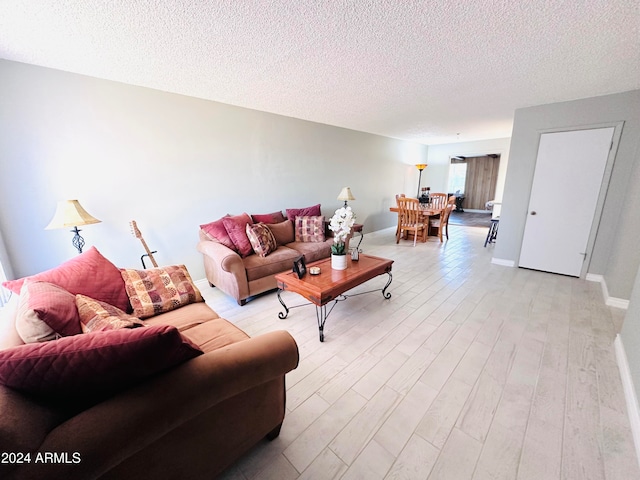 living room featuring a textured ceiling and light wood-type flooring