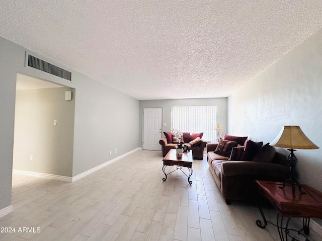 living room with a textured ceiling and light wood-type flooring