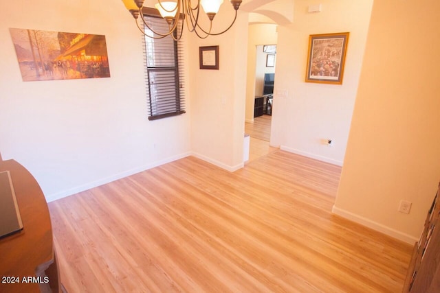 unfurnished dining area with hardwood / wood-style floors and a notable chandelier