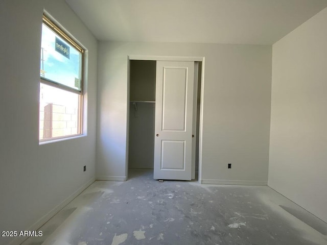 unfurnished bedroom with baseboards and a closet