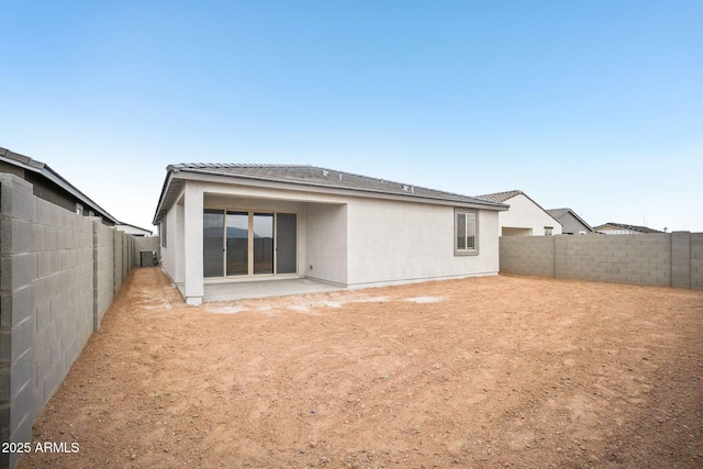 back of house featuring a fenced backyard and stucco siding