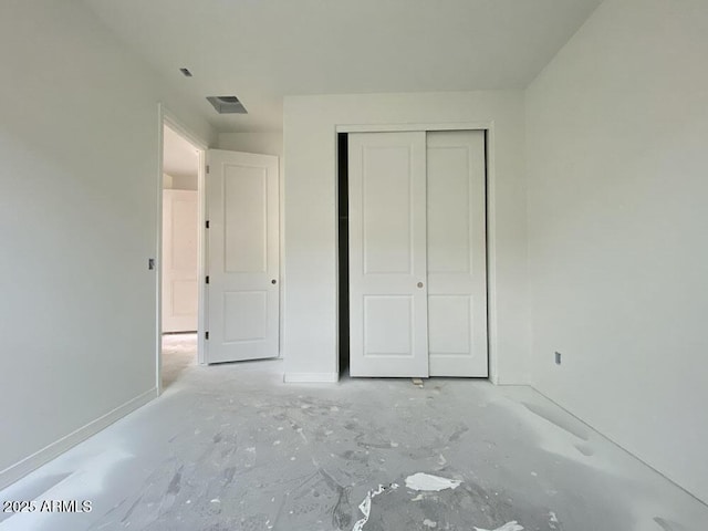 unfurnished bedroom with a closet, visible vents, and baseboards