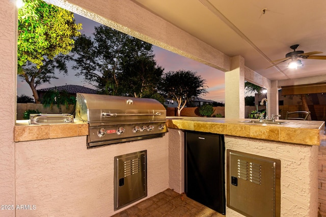 7247 W Buckskin Trl, Peoria, AZ 85383 - patio terrace at dusk featuring an outdoor kitchen and a ceiling fan