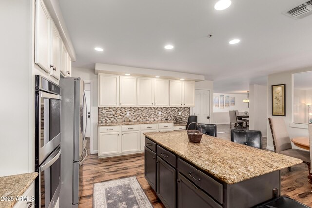 7247 W Buckskin Trl, Peoria, AZ 85383 - kitchen with wood finished floors, stainless steel appliances, white cabinetry, and recessed lighting