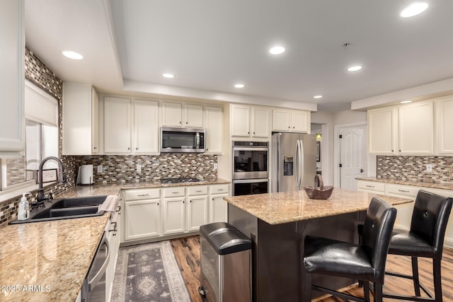 7247 W Buckskin Trl, Peoria, AZ 85383 - kitchen with stainless steel appliances, a kitchen bar, dark wood-style floors, tasteful backsplash, and white cabinetry