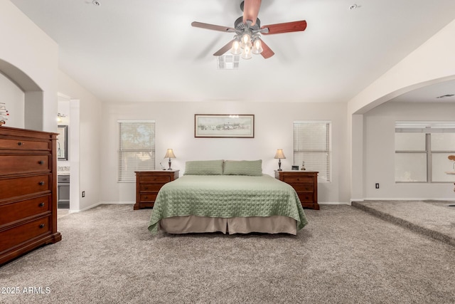 7247 W Buckskin Trl, Peoria, AZ 85383 - bedroom with carpet, arched walkways, vaulted ceiling, a ceiling fan, and ensuite bathroom