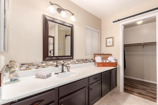 7247 W Buckskin Trl, Peoria, AZ 85383 - bathroom with vanity, backsplash, wood finished floors, and a spacious closet