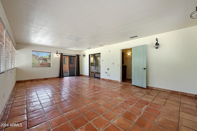 tiled spare room with a textured ceiling