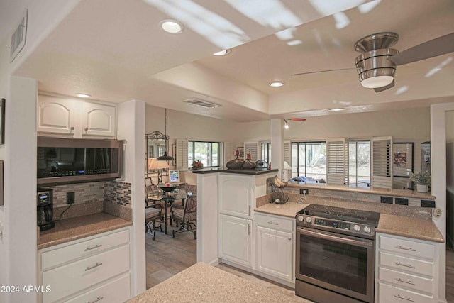 kitchen featuring white cabinets, a healthy amount of sunlight, light wood-type flooring, and appliances with stainless steel finishes