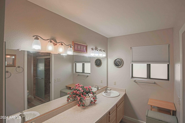 bathroom featuring vanity, a shower with shower door, and toilet