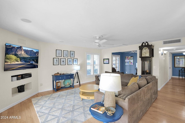 living room featuring light hardwood / wood-style floors and ceiling fan