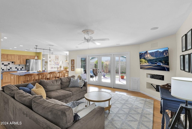 living room with french doors, light wood-type flooring, and ceiling fan