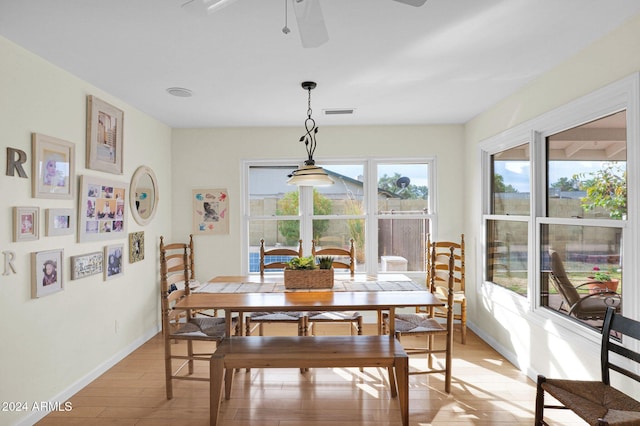 dining area with light wood-type flooring and ceiling fan