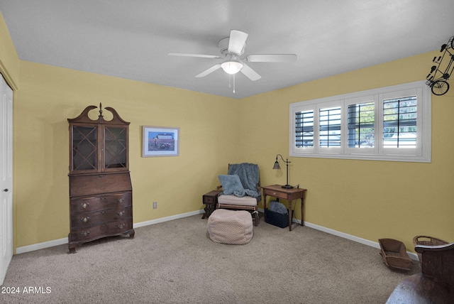 living area with light carpet and ceiling fan