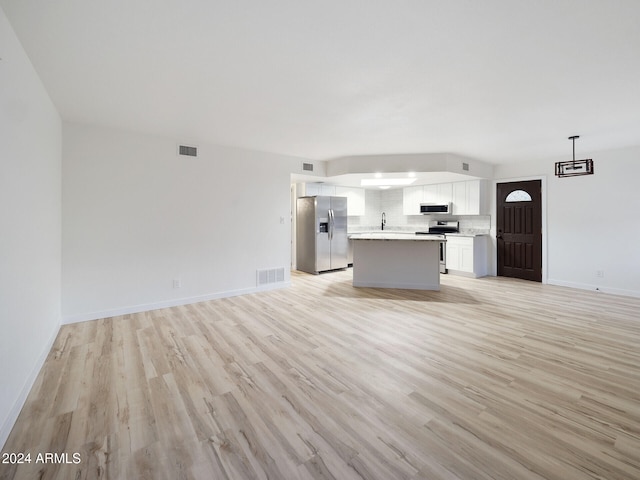 unfurnished living room featuring light hardwood / wood-style floors and sink