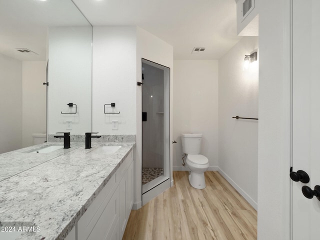 bathroom featuring a shower, vanity, hardwood / wood-style flooring, and toilet