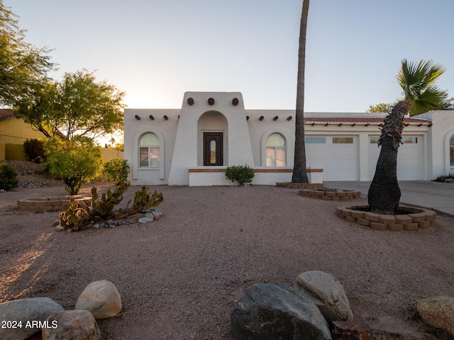 pueblo revival-style home featuring a garage