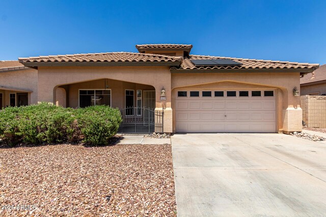 12238 W Monroe St, Avondale, AZ 85323 - mediterranean / spanish home with an attached garage, stucco siding, solar panels, and concrete driveway