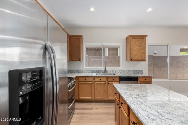 12238 W Monroe St, Avondale, AZ 85323 - kitchen with stainless steel appliances, a sink, light stone counters, light wood-style floors, and recessed lighting